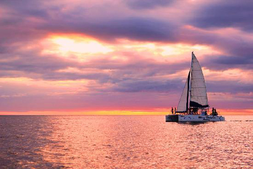 Beautiful sunset and Blue Dolphin Sailing Catamaran